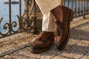 Man standing on balcony with brown suede loafers on