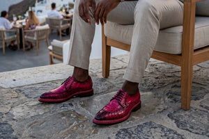 Person wearing pink shoes sitting on a chair outdoors with a stone floor.