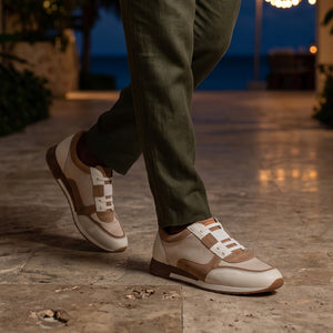 Person wearing brown and beige sneakers on a stone pavement with a blurred background