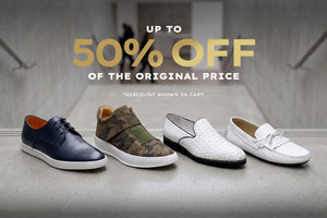 Four men's casual shoes displayed on a concrete ledge with a blurred hallway background and large promotional text reading 'UP TO 50% OFF OF THE ORIGINAL PRICE'. The shoes include a navy leather oxford, a camouflage lace-up shoe, a white woven slip-on, and a white moccasin-style loafer.